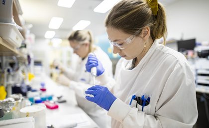 Two female researchers work at the lab bench as part of the vaccine project at UQ